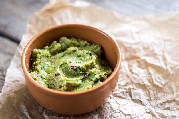 Guacamole sauce in wooden bowl