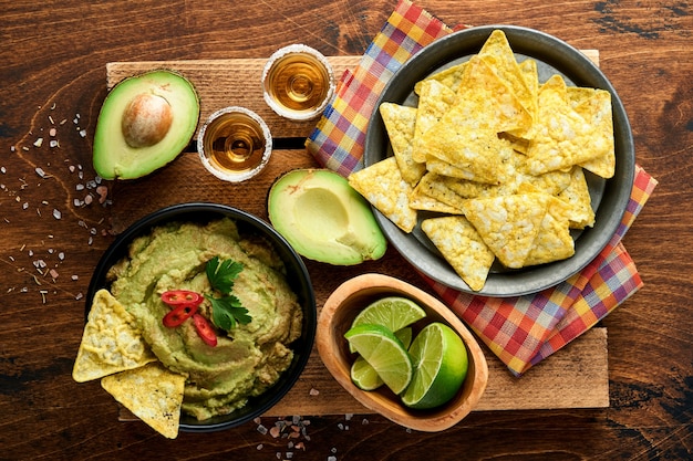 Гуакамоле. Традиционный латиноамериканский мексиканский соус дип в черной миске с авокадо и ингредиентами