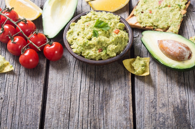 Photo guacamole with ingredients avocado lemon and tomatoes mexican food