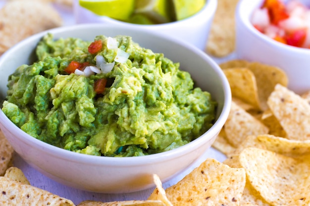 Guacamole with pico de gallo (onion, coriander or chili and tomato). Delicious healthy avocado food concept, on a close-up view