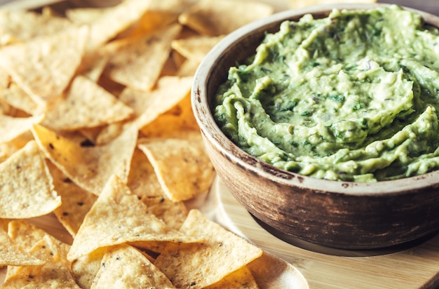 Guacamole with tortilla chips on the wooden tray