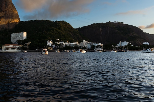Foto guanabara bay in rio de janeiro brazilië met sugarloaf mountain op de achtergrond mooi landschap en heuvel met de zee zomerse zonsondergang boten in de baai