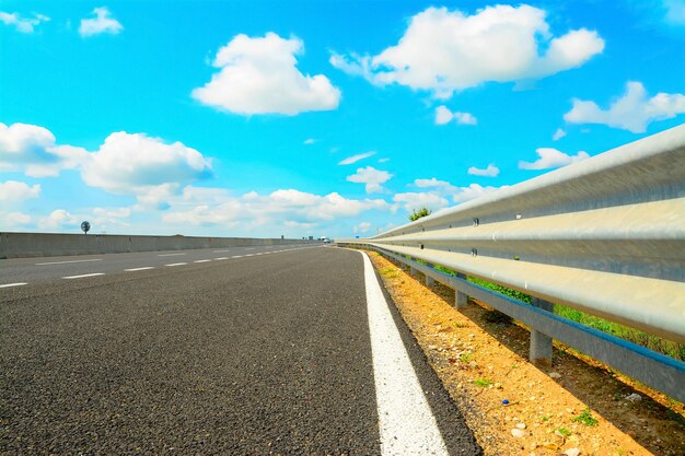 Foto guard rail in una strada di campagna sotto le nuvole