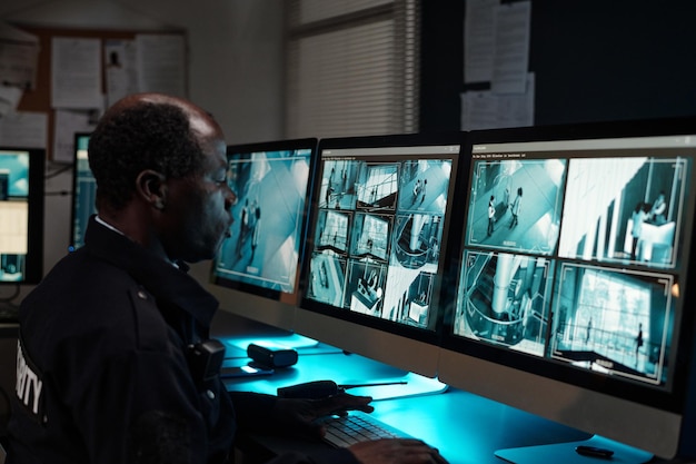 guard sitting by workplace with monitors