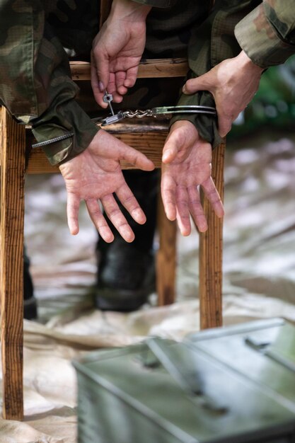 A guard unlocks the handcuffs of an accused soldier with a small key