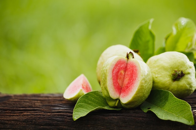 Guava sliced on wood table with green natural background