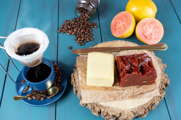 Guave zoet met kaas op een houten bord naast een kopje en koffiebonen en mes