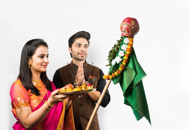 Gudi Padwa 축하 - 흰색 배경 위에 격리된 힌두교 새해에 푸자를 수행하는 인도의 똑똑한 커플