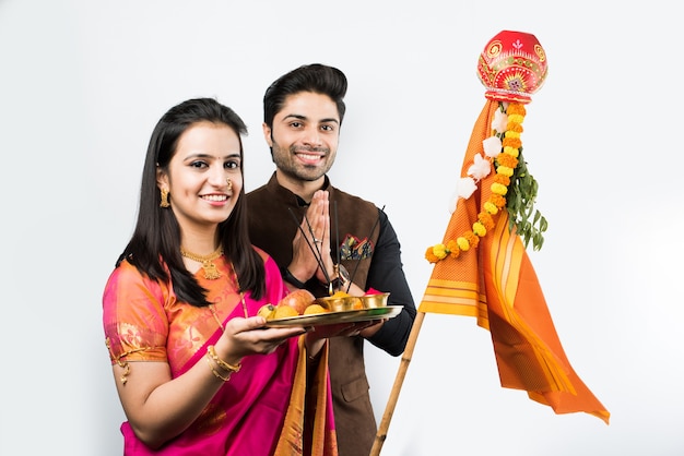 Gudi Padwa Celebration - Indian smart couple performing puja on Hindu New year , isolated over white background