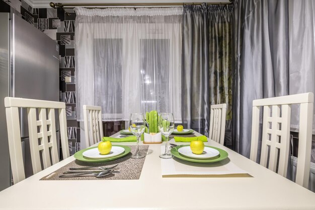 Guest table in Interior of the modern luxure kitchen in studio apartments in minimalistic style with green color