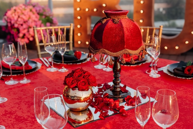 Guests table setting for banquet in black red and gold style Elegant dinner decor for event