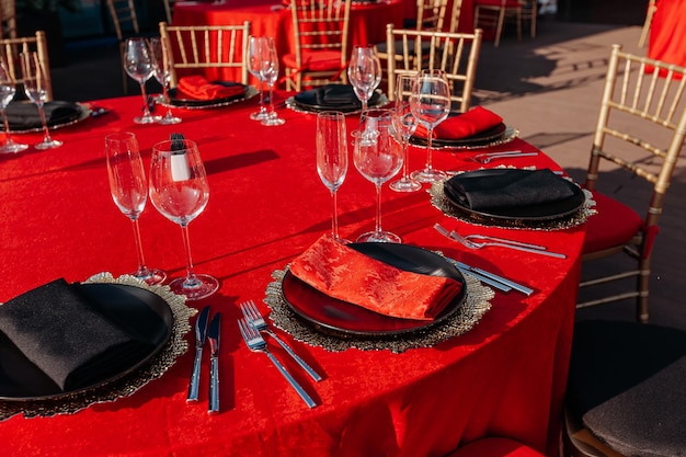 Photo guests table setting for banquet in black red and gold style elegant and luxury dinner arrangement