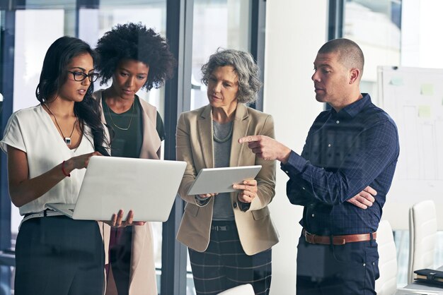 Guidare la propria azienda verso il miglior futuro possibile inquadratura di un team di colleghi che utilizza la tecnologia moderna durante un incontro informale