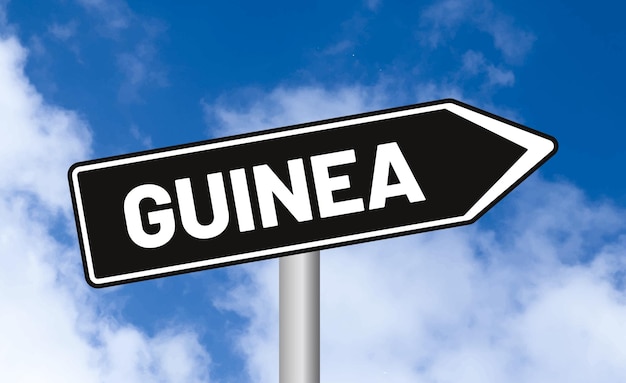 青い空の背景にあるギニアの道路標識