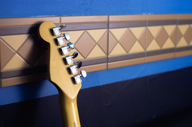 抽象的な壁の背景にギターのフレットボード。ラピスブルー。