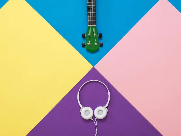 Guitar and headphones on an abstract multicolored background Concept of abstract art