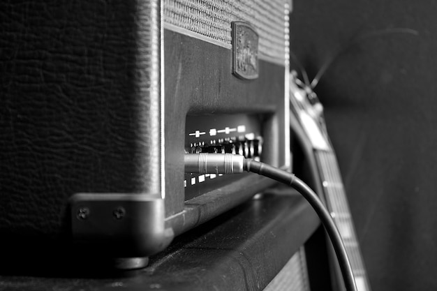 A guitar is on top of a speaker.