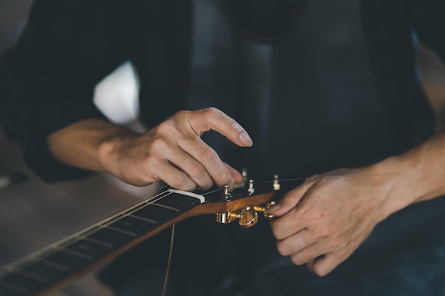 Фото Производители гитар надевают струны для акустических гитар после изготовления акустических гитар в магазине гитар ручной работы concept guitar shop.