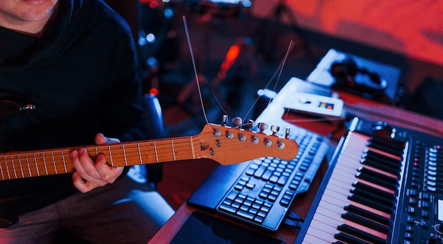 Guitar player have recording session indoors in the studio.