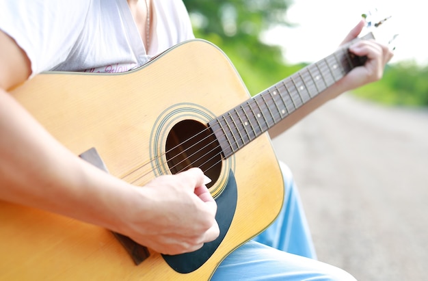 Guitar player playing song in the nature