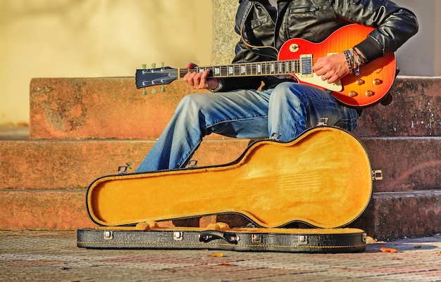 Guitar player in the street with an open guitar case