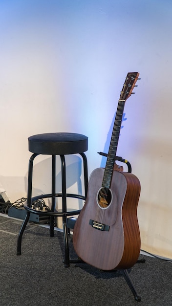 Photo guitar and seat against wall