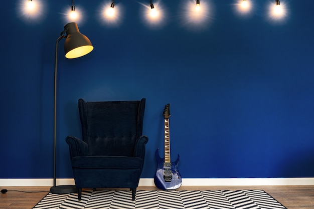 Guitar setup against classic blue wall in apartment