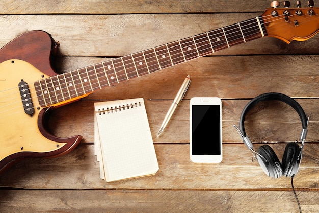 Foto chitarra e smartphone su sfondo di legno