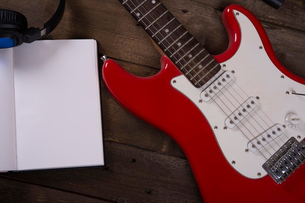 Guitar wallpaper with microphone, headset, cables and wooden\
background, with writing pad