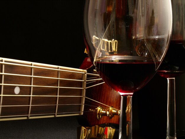 Guitar and wine glass on a dark background