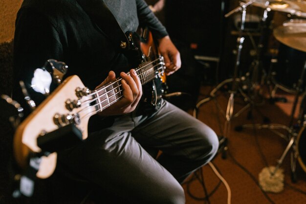 Guitarist playing bass guitar in studio closeup