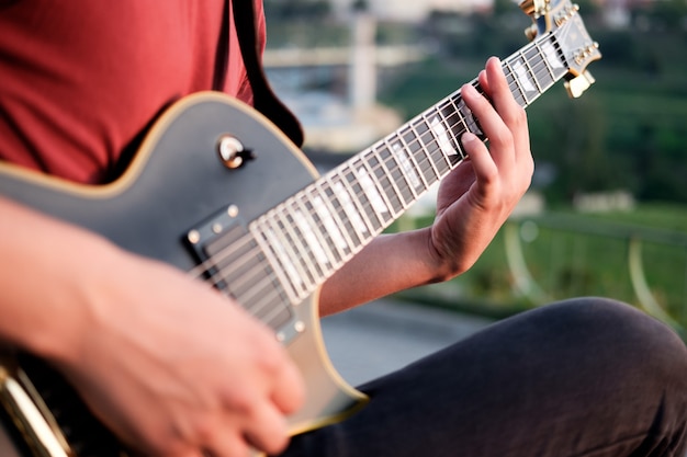 Guitarist playing electric guitar outdoors