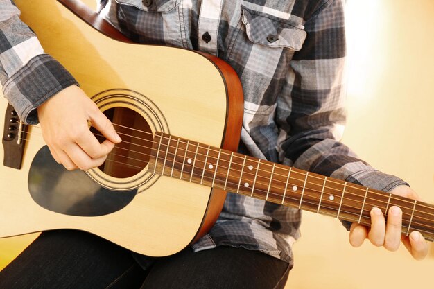 Guitarist plays guitar in the studio close up