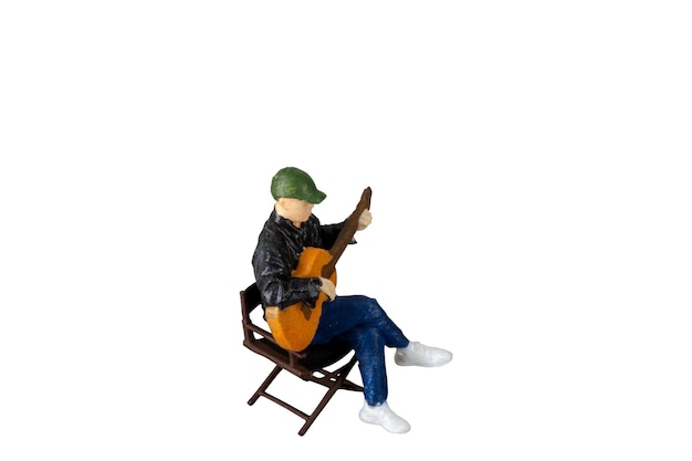 의자에 앉아 있는 기타리스트는  바탕에 고립되어 있으며 절단 경로가 있습니다.