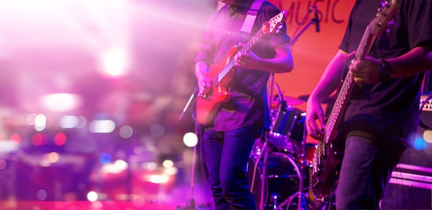 Photo guitarists with colorful lighting on a stage