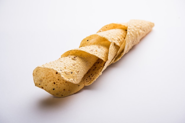 Gujarati papad of papadum in rauwe gedroogde vorm met geroosterde kegel, rol en platte variant