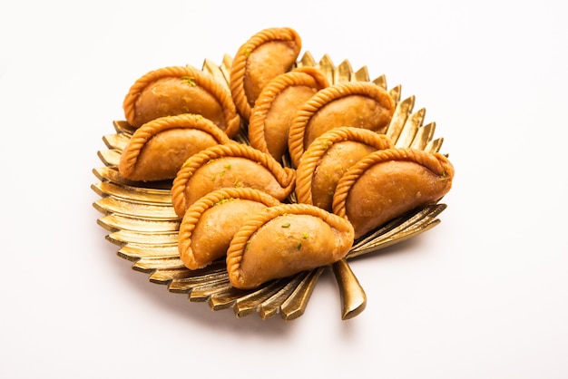 Gujiya or gujia or karanji. sweet dumplings made during the festival of holi and diwali, served in a plate