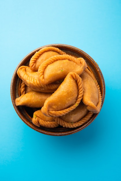 Gujiya of gujia of karanji. zoete dumplings gemaakt tijdens het festival van holi en diwali, geserveerd in een bord