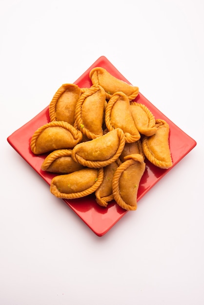 Gujiya of gujia of karanji. zoete dumplings gemaakt tijdens het festival van holi en diwali, geserveerd in een bord