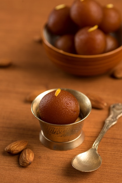 Gulab Jamun in bowl and copper antique bowl with spoon. Indian Dessert or Sweet Dish.
