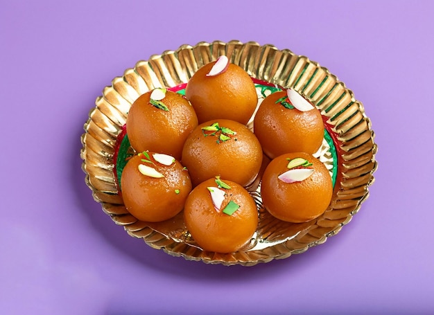 Gulab jamun falling dry fruits on it and dark background