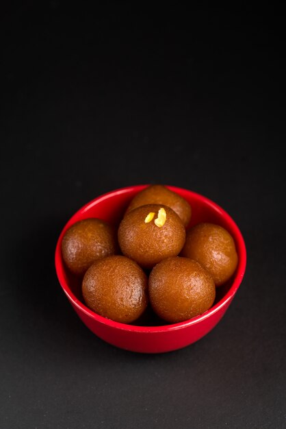 写真 黒い背景にボウルにgulab jamun。インドのデザートまたは甘い料理。