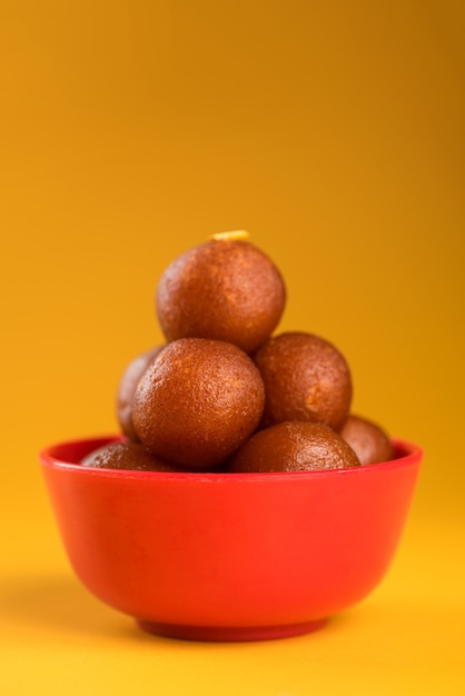 Gulab Jamun in kom op geel.