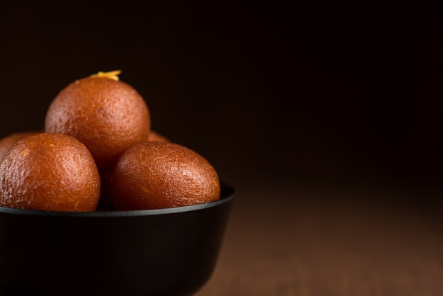 Gulab Jamun in kom op houten achtergrond.