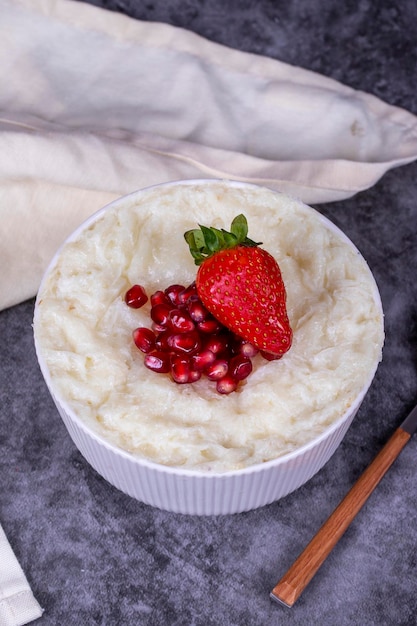 Gullac dessert Traditional Ramadan dessert Pomegranate and strawberry gullac dessert in bowl