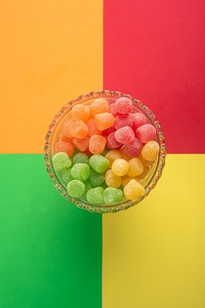 Gummy candy, arrangement van gummy candy van bovenaf gezien in een glazen pot op een gekleurd oppervlak.