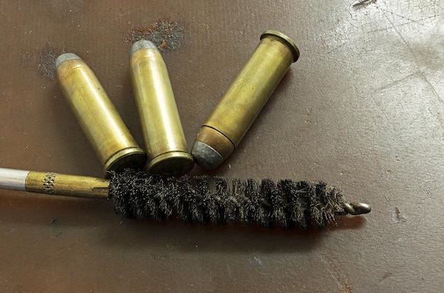 사진 갈색 바탕에 3개의 35mm 칼리버 총알 에 총기 청소 키트
