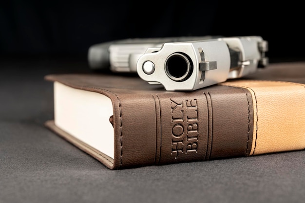 A gun rests atop a holy bible representing God guns and freedom of religion