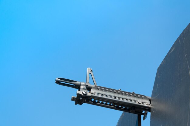 Gun weapons closeup machine gun on blue skyMachine gun on a military vehicle