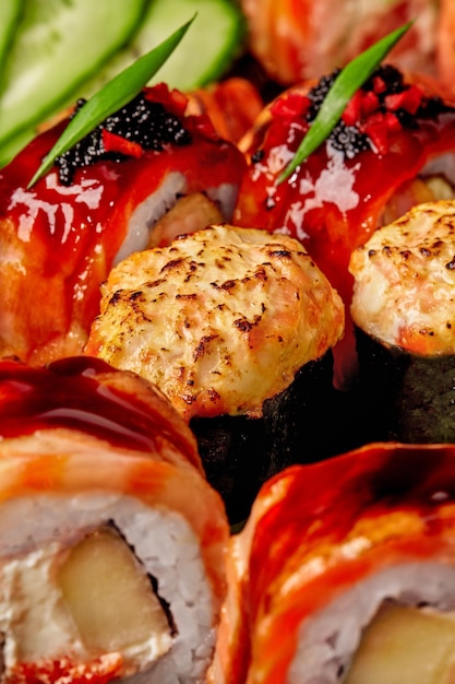 Gunkan maki in nori con formaggio al forno e topping di salmone servito in un set di sushi